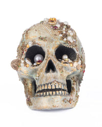 Two ornate skulls with gemstones on a white background