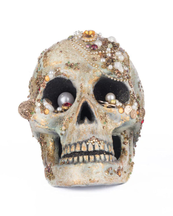Two ornate skulls with gemstones on a white background